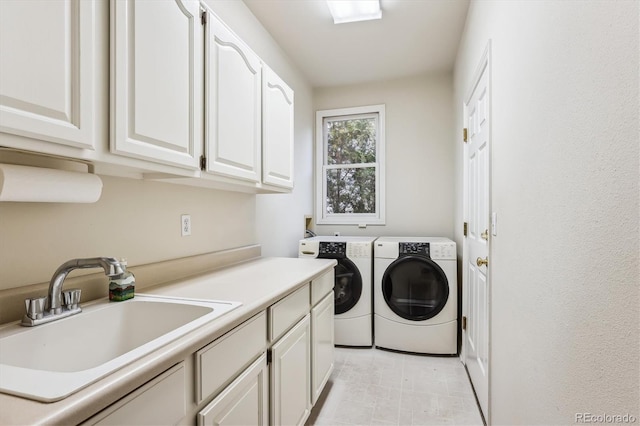 laundry area featuring cabinets, independent washer and dryer, and sink