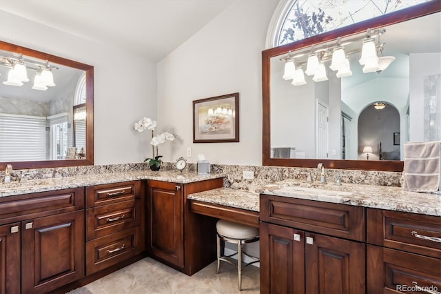 bathroom featuring vanity and lofted ceiling