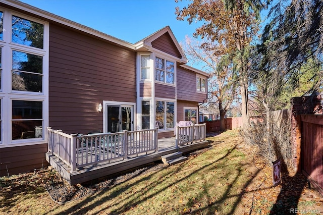 rear view of house with a yard and a wooden deck