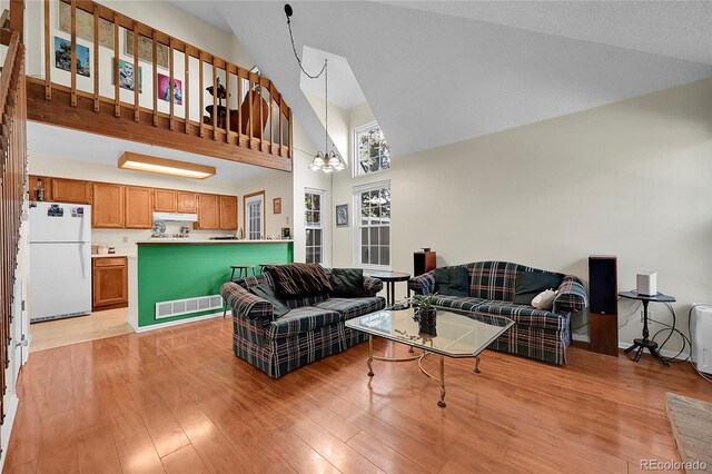 14110 E Dickinson Dr Unit A, Aurora, CO 80014 - living area with high vaulted ceiling, a chandelier, and light wood-style flooring
