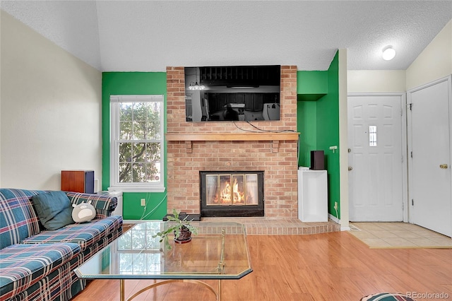14110 E Dickinson Dr Unit A, Aurora, CO 80014 - living area with a brick fireplace, wood finished floors, and a textured ceiling
