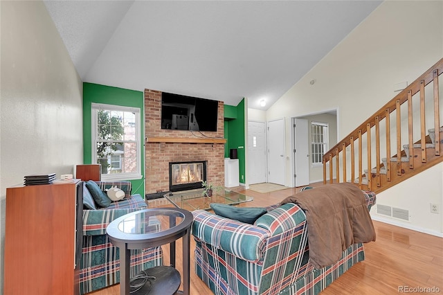 14110 E Dickinson Dr Unit A, Aurora, CO 80014 - living area with wood finished floors, a fireplace, stairway, baseboards, and high vaulted ceiling