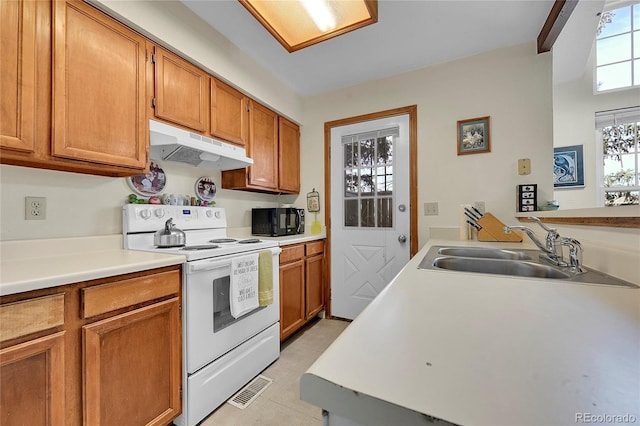 14110 E Dickinson Dr Unit A, Aurora, CO 80014 - kitchen with white electric stove, under cabinet range hood, a sink, black microwave, and light countertops