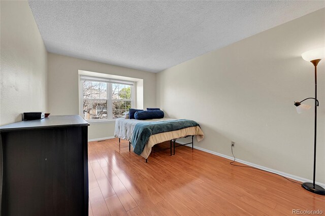14110 E Dickinson Dr Unit A, Aurora, CO 80014 - bedroom with a textured ceiling, light wood finished floors, and baseboards