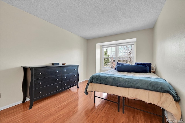 14110 E Dickinson Dr Unit A, Aurora, CO 80014 - bedroom featuring light wood-style flooring, a textured ceiling, and baseboards