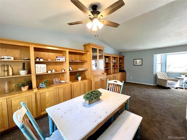 dining space with ceiling fan, lofted ceiling, and dark colored carpet