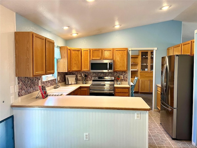 kitchen featuring stainless steel appliances, backsplash, kitchen peninsula, and lofted ceiling