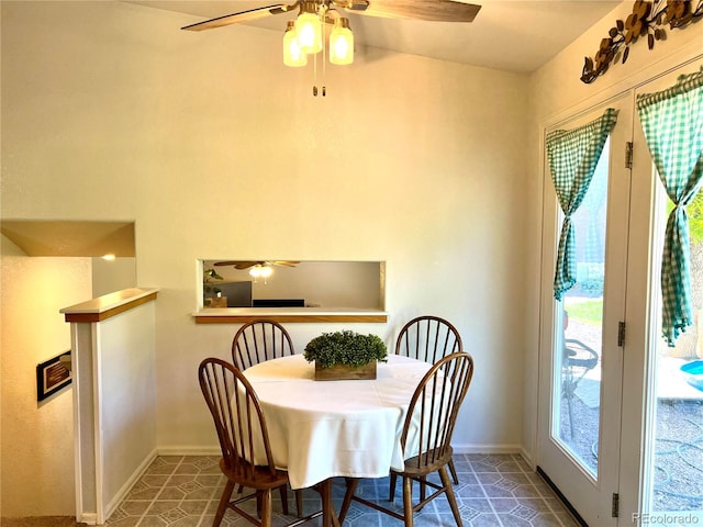 dining area with ceiling fan and dark tile patterned floors