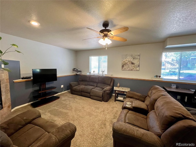 carpeted living room with ceiling fan, a fireplace, and a textured ceiling