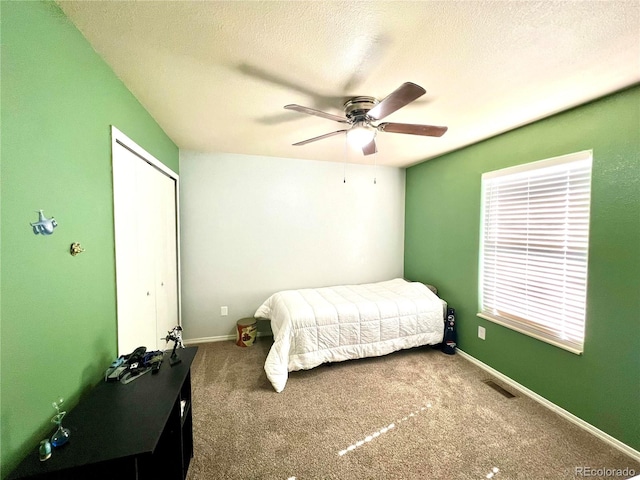 bedroom with ceiling fan, a textured ceiling, and carpet