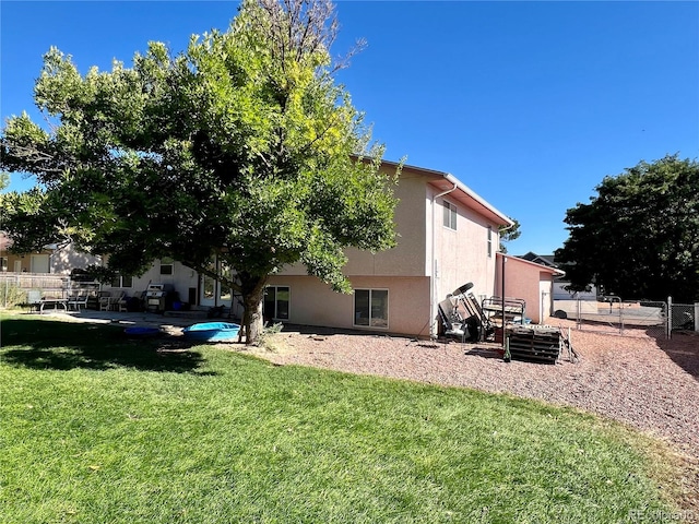 rear view of property with a lawn and a patio area