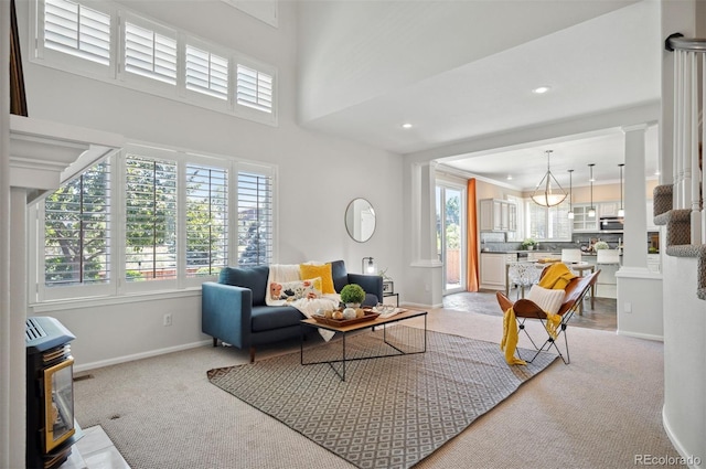 16690 Amberstone Way, Parker, CO 80134 - living room featuring light colored carpet, a wood stove, recessed lighting, ornamental molding, and decorative columns