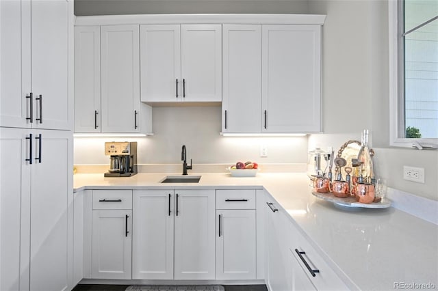 kitchen featuring sink and white cabinets