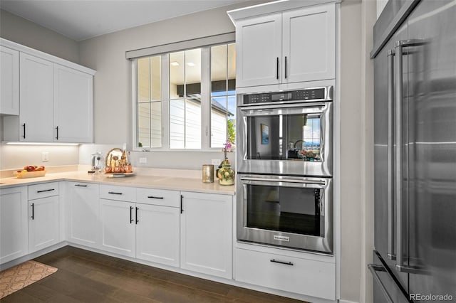 kitchen featuring dark wood-type flooring, white cabinets, and appliances with stainless steel finishes