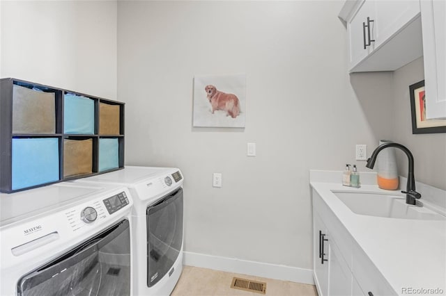 washroom featuring sink, light tile patterned flooring, cabinets, and washing machine and clothes dryer