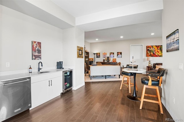 kitchen with stainless steel dishwasher, wine cooler, sink, white cabinets, and dark hardwood / wood-style floors