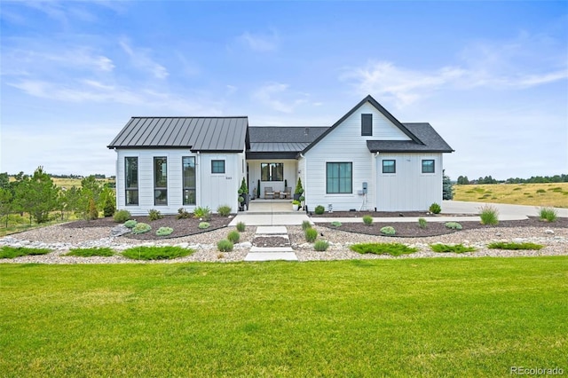view of front of home featuring a front lawn, a standing seam roof, and metal roof