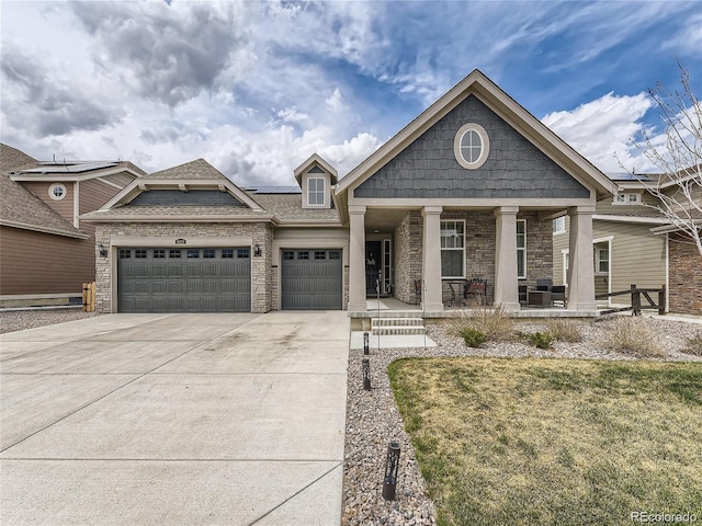 view of front of property with a garage, a front lawn, solar panels, and covered porch