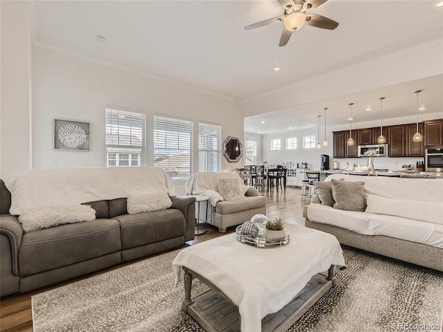 living room featuring crown molding, ceiling fan, and hardwood / wood-style flooring