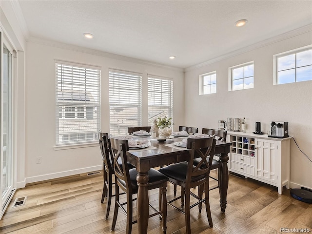 dining room with hardwood / wood-style flooring and ornamental molding