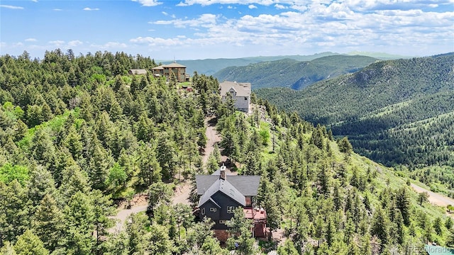 14980 Elk Mountain Trl, Littleton, CO 80127 - aerial view of property and surrounding area featuring a heavily wooded area and a mountain backdrop