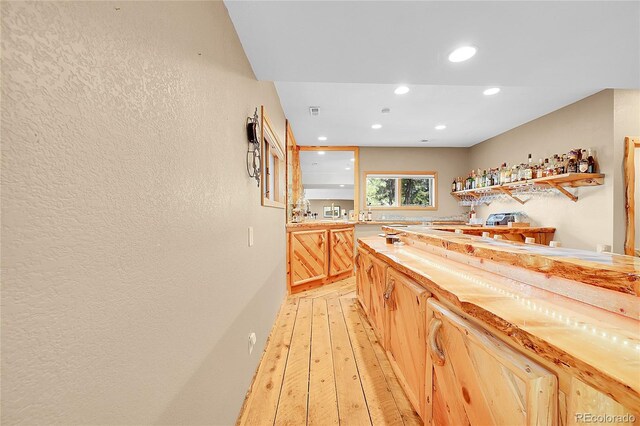 14980 Elk Mountain Trl, Littleton, CO 80127 - indoor wet bar with light wood finished floors, recessed lighting, and a textured wall