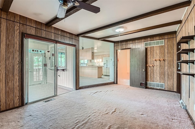 2122 S Yank Way, Lakewood, CO 80228 - empty room featuring wooden walls, carpet, beam ceiling, and a ceiling fan