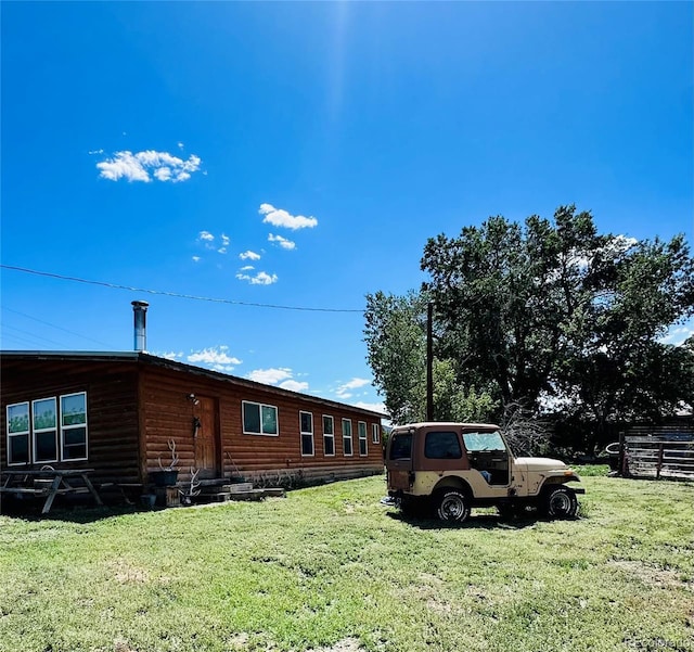 exterior space featuring a yard, entry steps, and log veneer siding