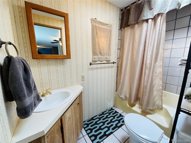 bathroom with wallpapered walls, toilet, vanity, and shower / bath combo with shower curtain