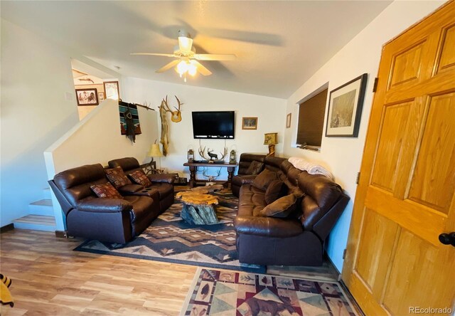 living area with ceiling fan, lofted ceiling, and wood finished floors