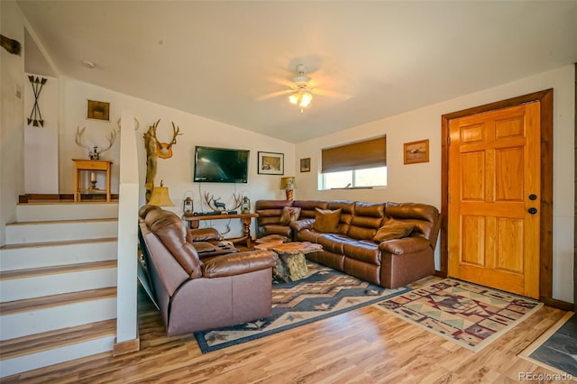 living room featuring lofted ceiling, stairway, ceiling fan, and wood finished floors
