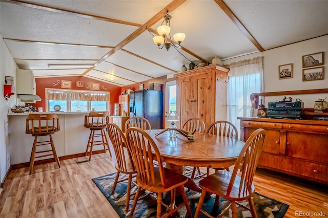 dining space featuring lofted ceiling, a healthy amount of sunlight, a chandelier, and light wood-type flooring