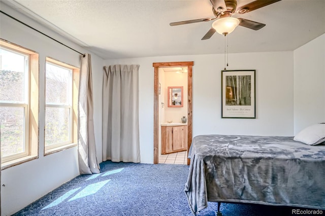 bedroom featuring a ceiling fan, ensuite bathroom, and carpet