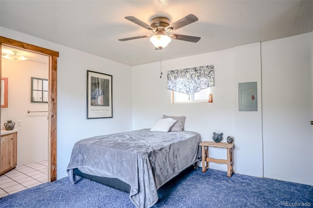 bedroom featuring electric panel, ensuite bath, tile patterned flooring, carpet flooring, and a ceiling fan