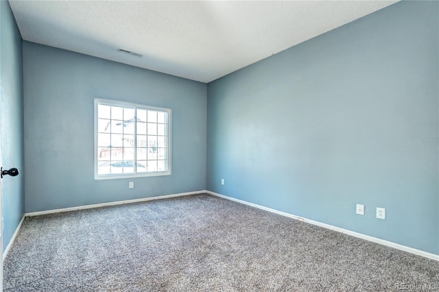 spare room with baseboards, visible vents, carpet floors, and a textured ceiling