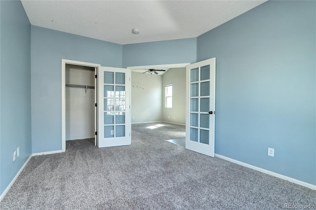 unfurnished bedroom with carpet flooring, french doors, a textured ceiling, and baseboards