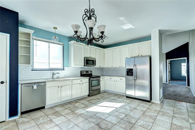 kitchen with tasteful backsplash, appliances with stainless steel finishes, white cabinetry, and a sink