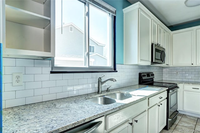 kitchen with white cabinetry, tasteful backsplash, appliances with stainless steel finishes, and a sink