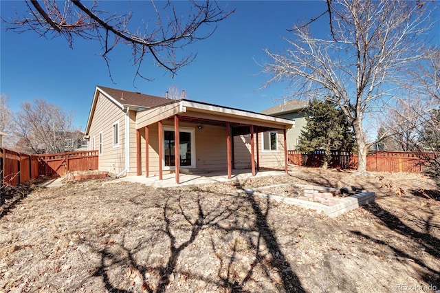 back of house with a fenced backyard and a patio