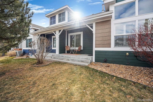 view of front facade featuring cooling unit, a porch, and a front lawn