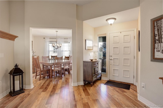 foyer entrance featuring a notable chandelier and light wood-type flooring