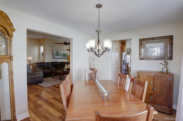 dining area featuring ceiling fan with notable chandelier and light wood-type flooring