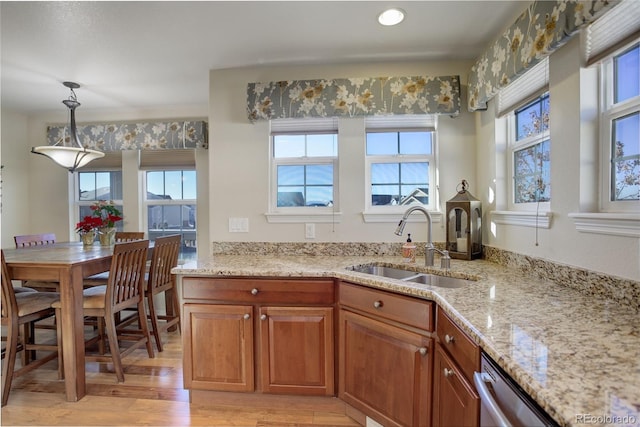 kitchen featuring a healthy amount of sunlight, sink, light hardwood / wood-style floors, and decorative light fixtures