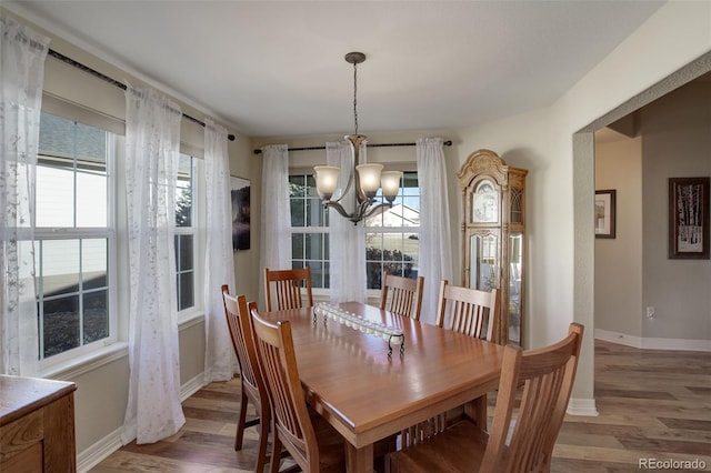 dining area with hardwood / wood-style floors and a chandelier