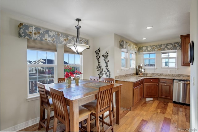 dining space with sink and light hardwood / wood-style flooring