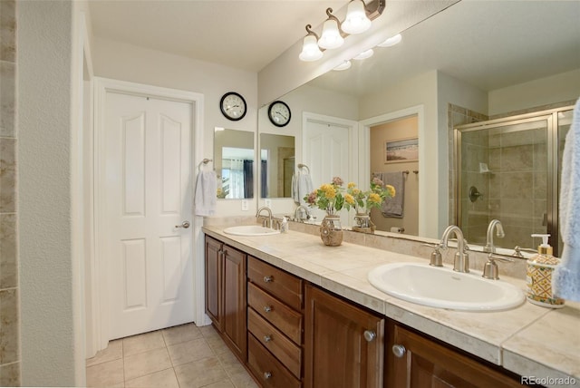 bathroom featuring tile patterned floors, an enclosed shower, and vanity