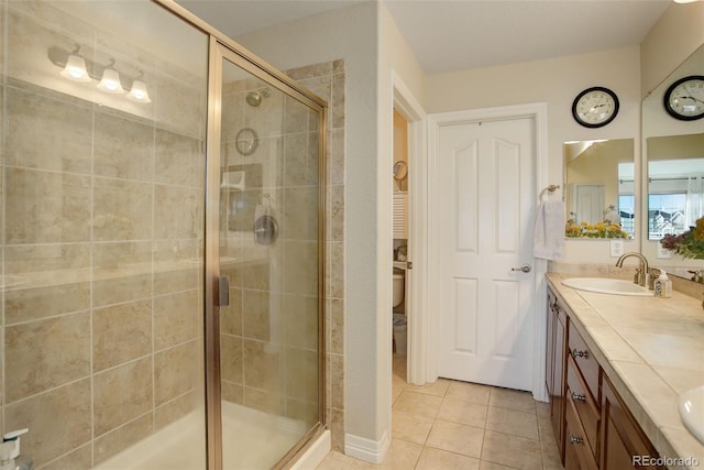 bathroom with tile patterned flooring, vanity, and walk in shower