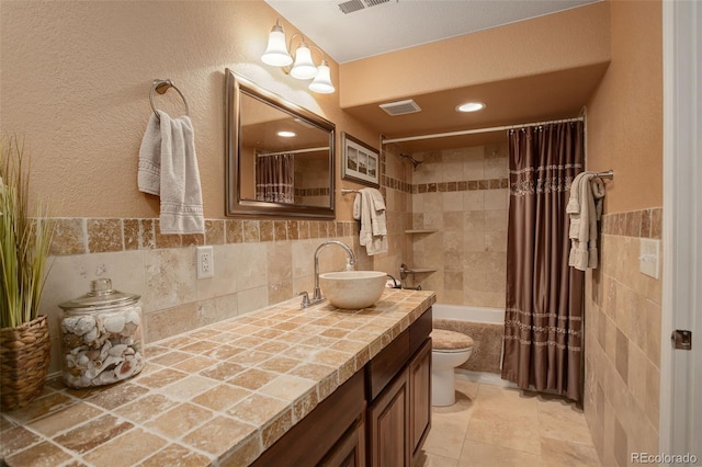 full bathroom with tile patterned floors, toilet, tile walls, vanity, and shower / bath combination with curtain