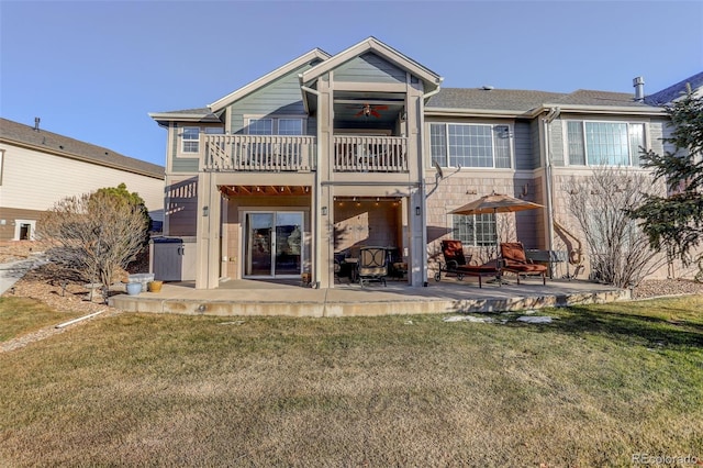 rear view of house featuring a yard, a patio area, and a balcony