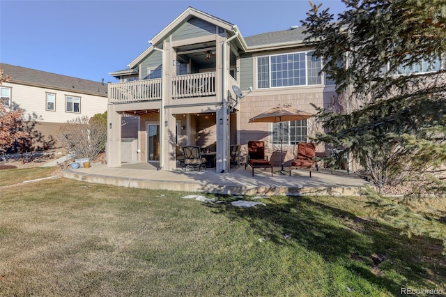 back of property featuring a lawn and a balcony